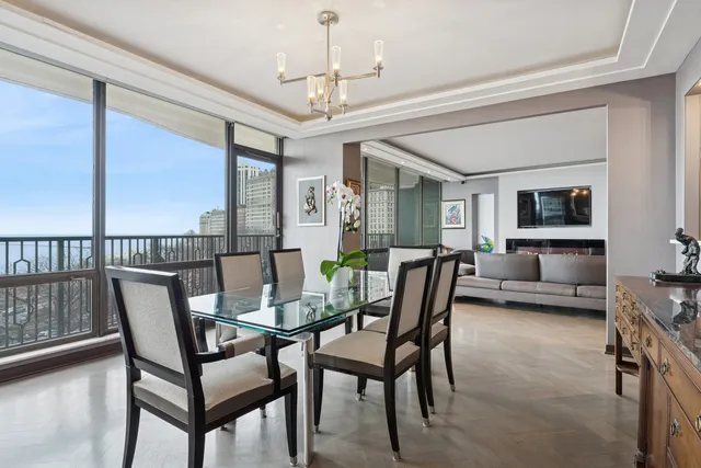 a dining room with furniture a chandelier and wooden floor