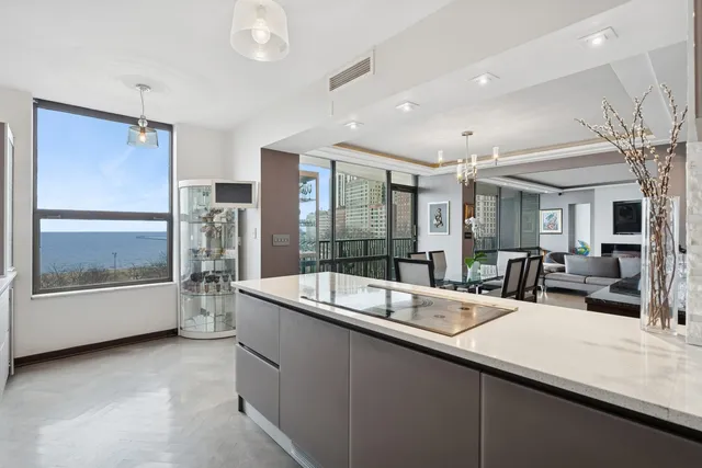 a large living room with stainless steel appliances furniture and a large window