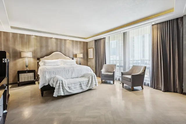 a bedroom with a bed chair and lamp