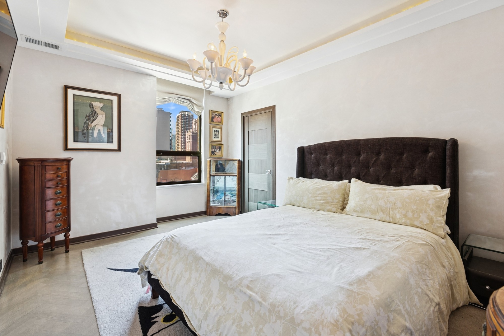 1040 North Lake Shore Drive, Unit 7C Chicago, IL 60611 - Photo 24 of 37 a spacious bedroom with a bed and a chandelier