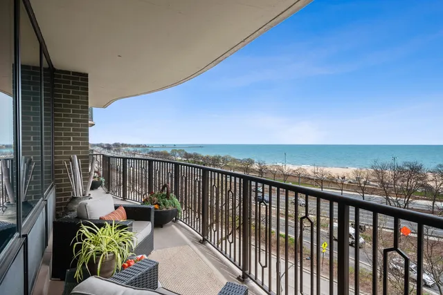 a view of a balcony with wooden floor next to a yard