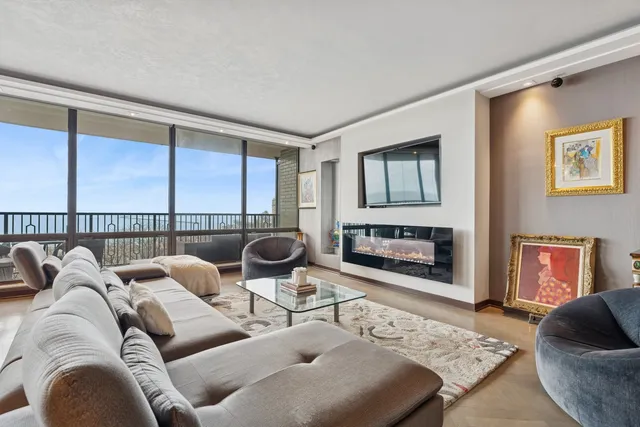 a living room with furniture fireplace and a large window
