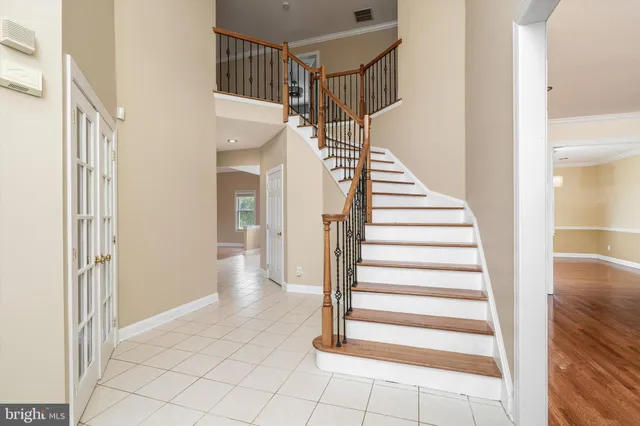 a view of a hallway to a bedroom with wooden floor and windows