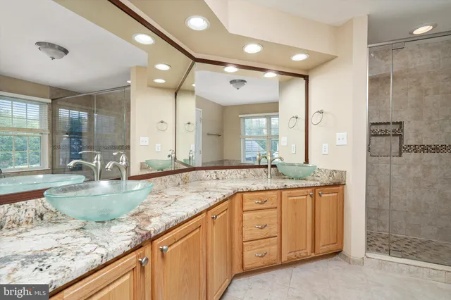 a bathroom with a granite countertop sink and a large mirror