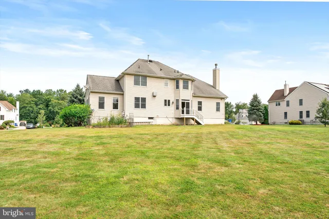 a view of a big house with a yard and plants