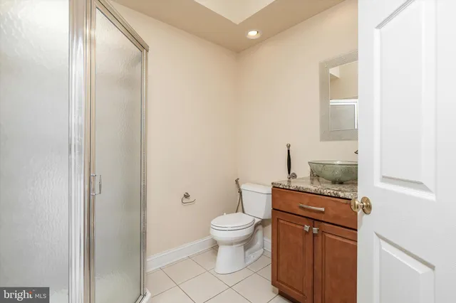 a bathroom with a granite countertop toilet a sink and a mirror