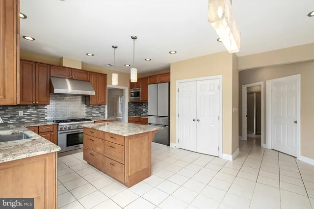 a kitchen with stainless steel appliances granite countertop a stove and a refrigerator