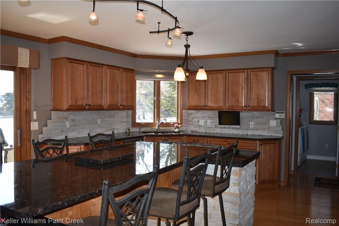 1993 Ridgefield Court Rochester, MI 48306 - Photo 16 of 47 LOOK EVEN MORE CABINETS. CHECK OUT THE BACK SPLASH! THERE ARE UNDER COUNTER LIGHTS TOO! THE DOORWAY TO THE RIGHT LEADS TO THE GARAGE (20 FT DEEP & 22 FT WIDE) AND TO THE 1ST FLOOR LAUNDRY ROOM