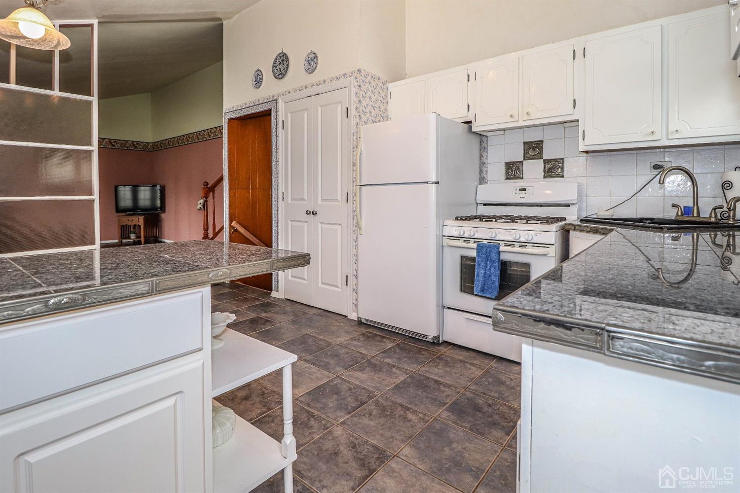 50 Albemarle Road Colonia, NJ 07067 - Photo 8 of 22 a kitchen with stainless steel appliances granite countertop a sink stove and refrigerator