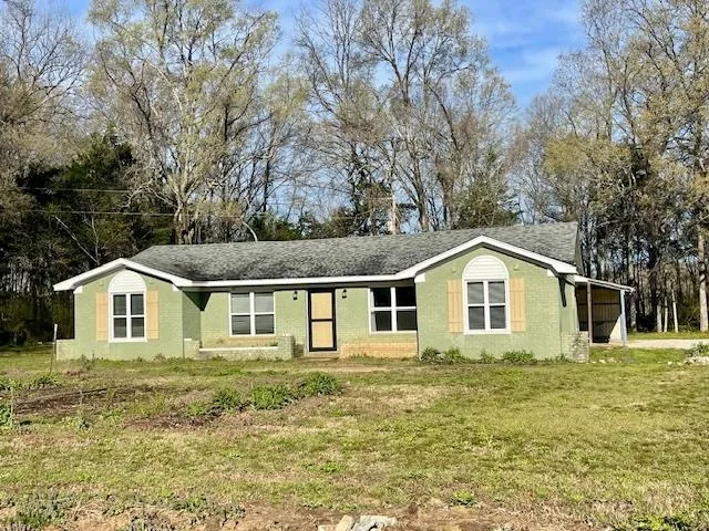 a view of a yard in front of a house with large trees