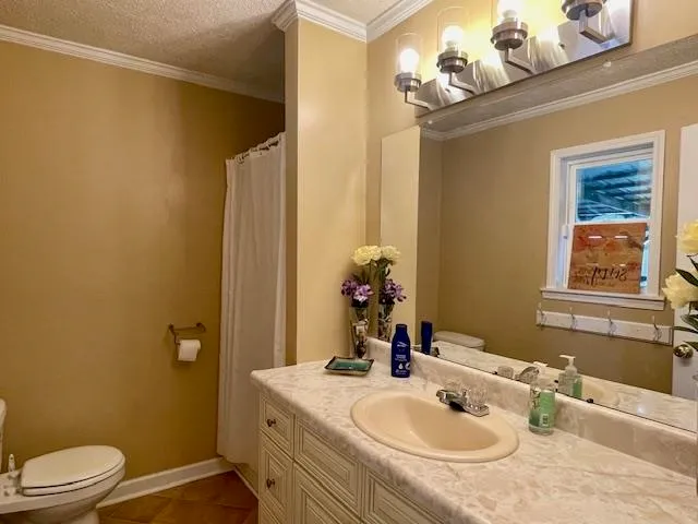 a bathroom with a sink vanity granite and toilet