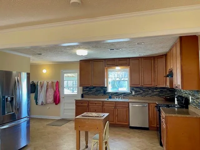 a kitchen with a sink refrigerator and cabinets