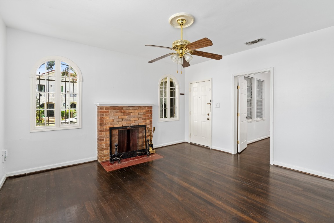 2402 Hazard Street Houston, TX 77019 - Photo 10 of 41 an empty room with wooden floor fireplace and windows