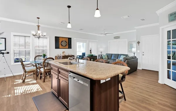 a large kitchen with lots of counter space a sink dining table and chairs