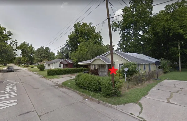 a front view of a house with a yard and trees