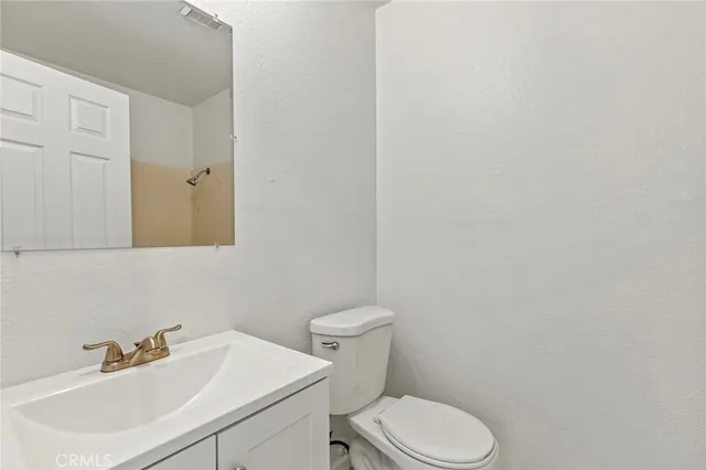a bathroom with a sink a toilet and mirror