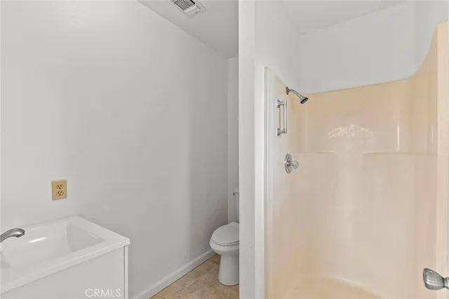 a bathroom with a granite countertop toilet a sink and shower