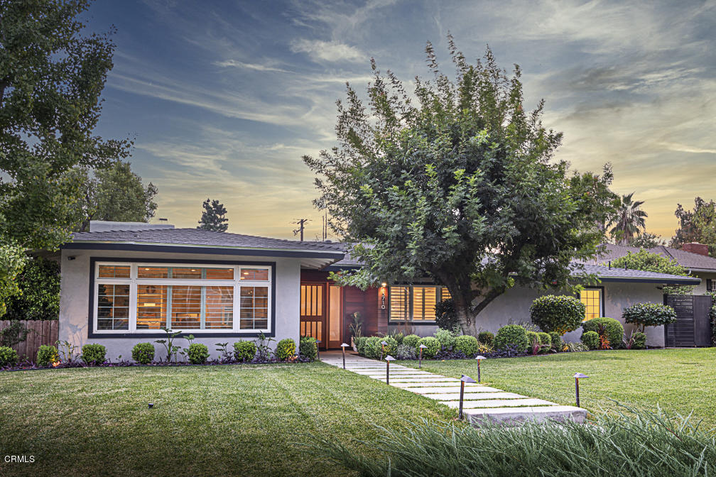 a view of an house with backyard and a tree