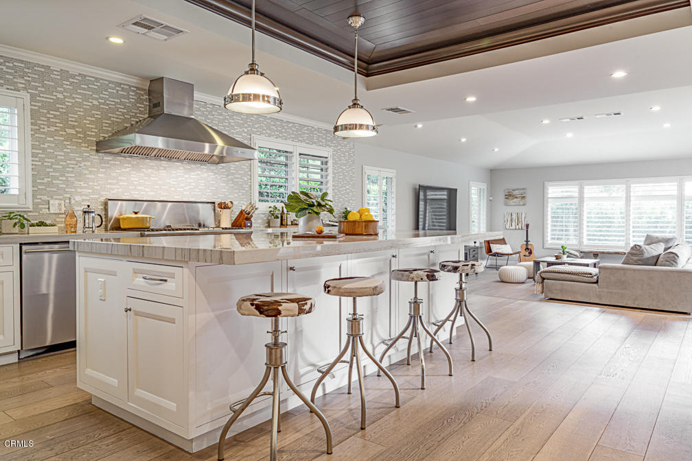 3710 Hampton Road Pasadena, CA 91107 - Photo 17 of 42 a kitchen with stainless steel appliances kitchen island granite countertop a stove a sink a refrigerator and white cabinets with wooden floor