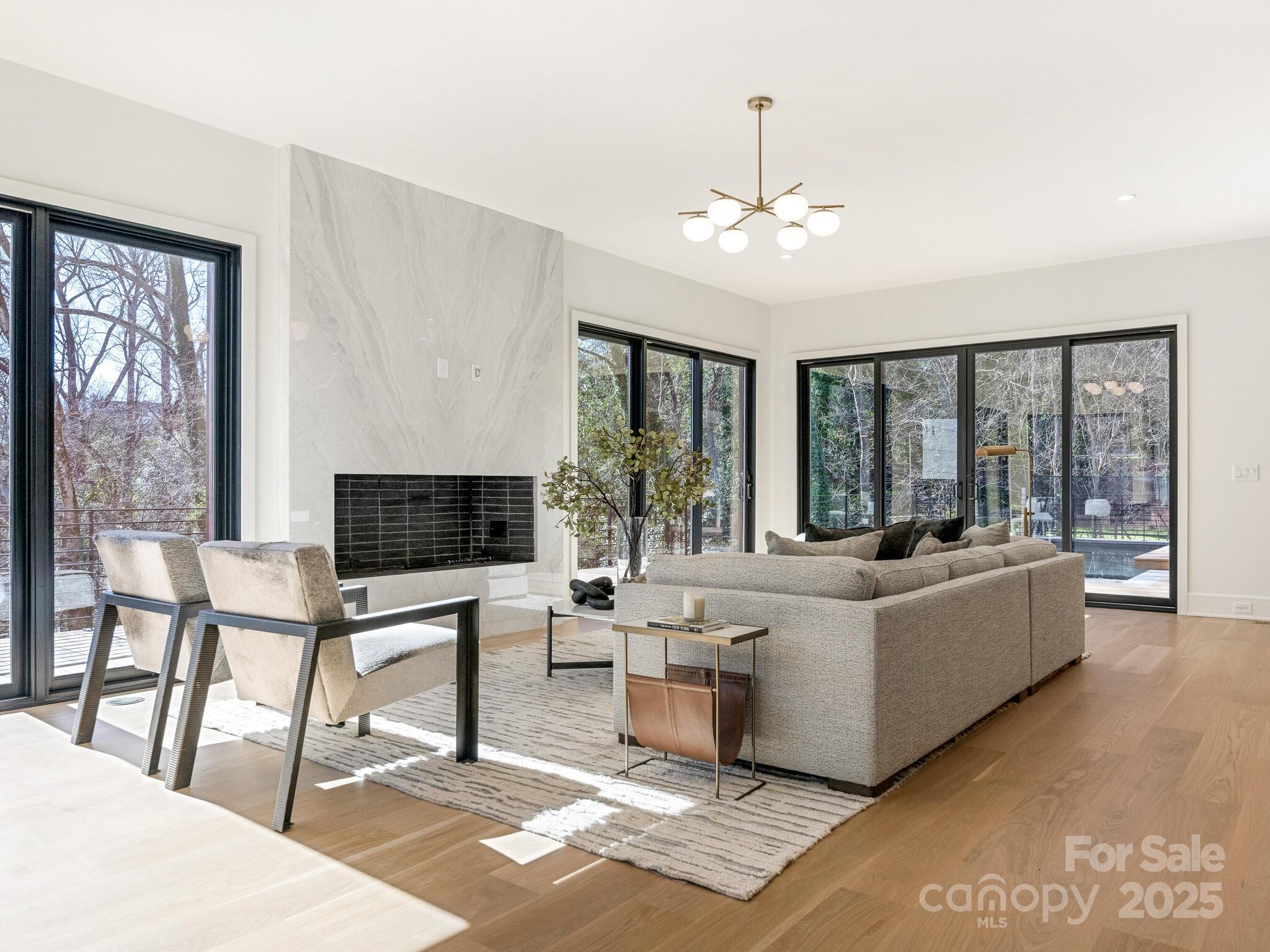2832 Arcadia Avenue Charlotte, NC 28209 - Photo 11 of 48 a living room with furniture a chandelier and a flat screen tv