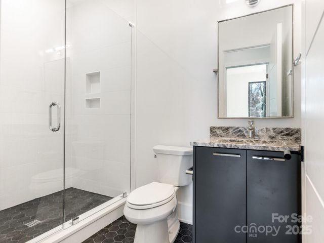 a bathroom with a granite countertop sink a toilet and shower