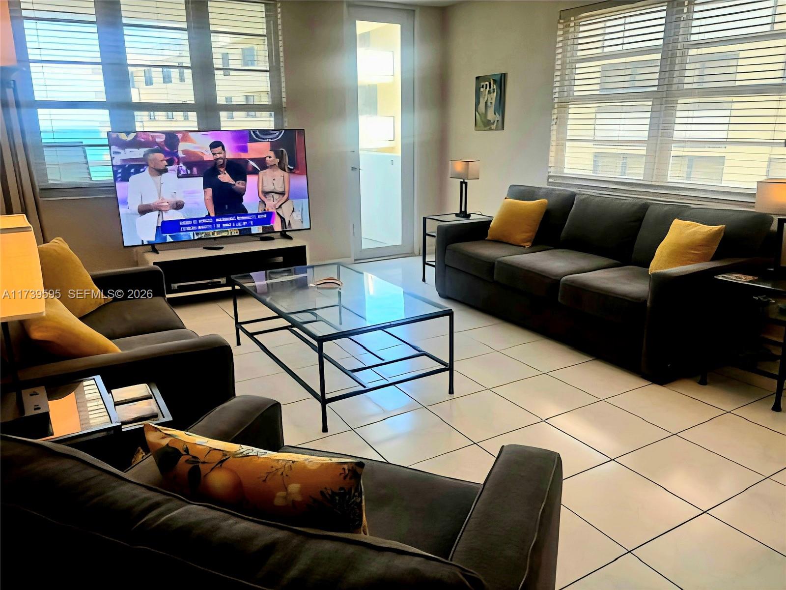 100 Lincoln Road, Unit 821 Miami Beach, FL 33139 - Photo 2 of 33 a living room with furniture a flat screen tv and a window
