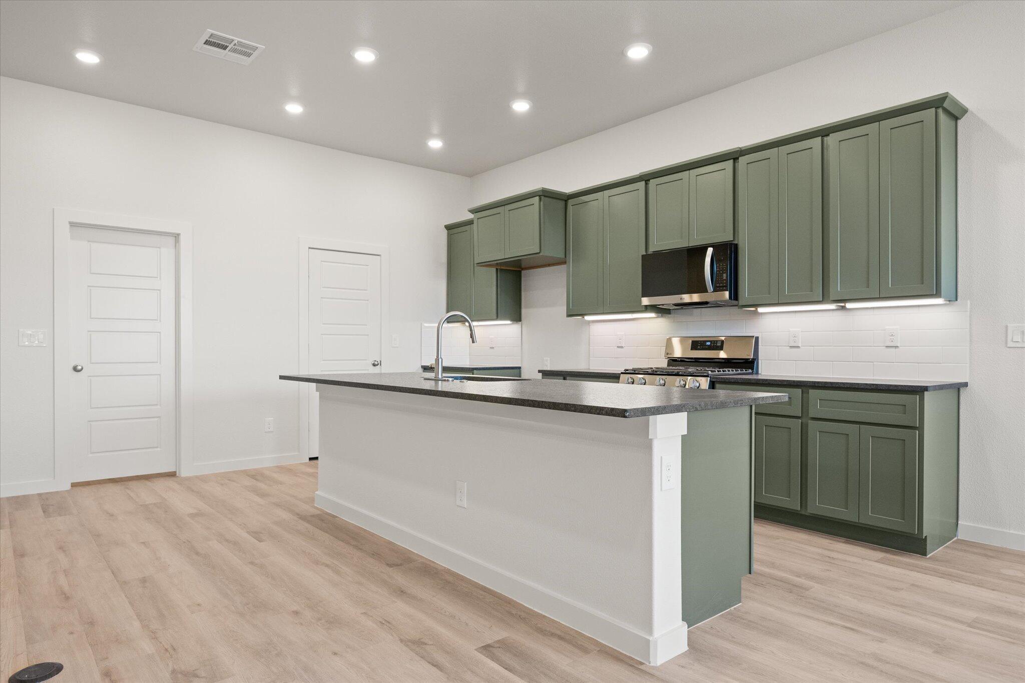 6105 121st Street Lubbock, TX 79424 - Photo 11 of 24 a kitchen with stainless steel appliances kitchen island granite countertop a stove and a sink