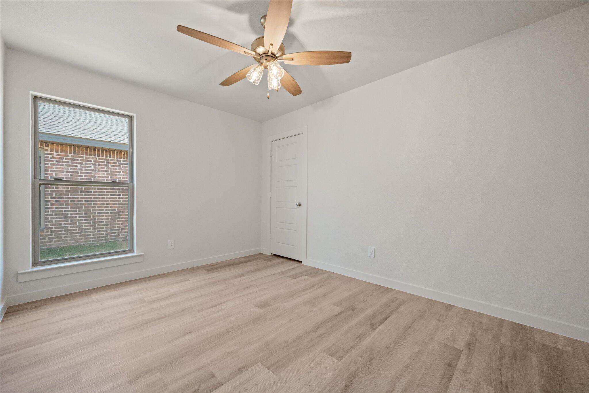 6105 121st Street Lubbock, TX 79424 - Photo 19 of 24 an empty room with a window and a fan