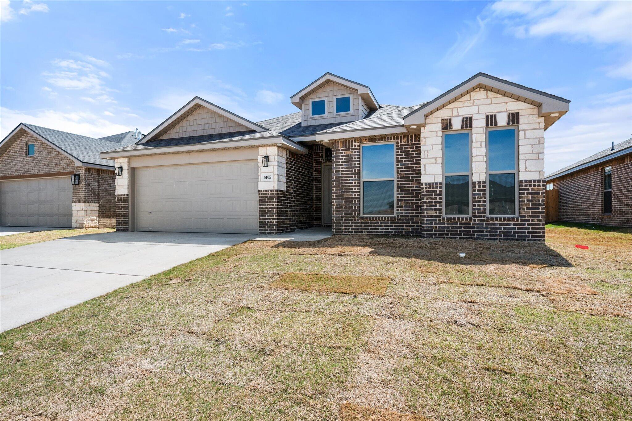 6105 121st Street Lubbock, TX 79424 - Photo 2 of 24 a front view of a house with a yard and garage