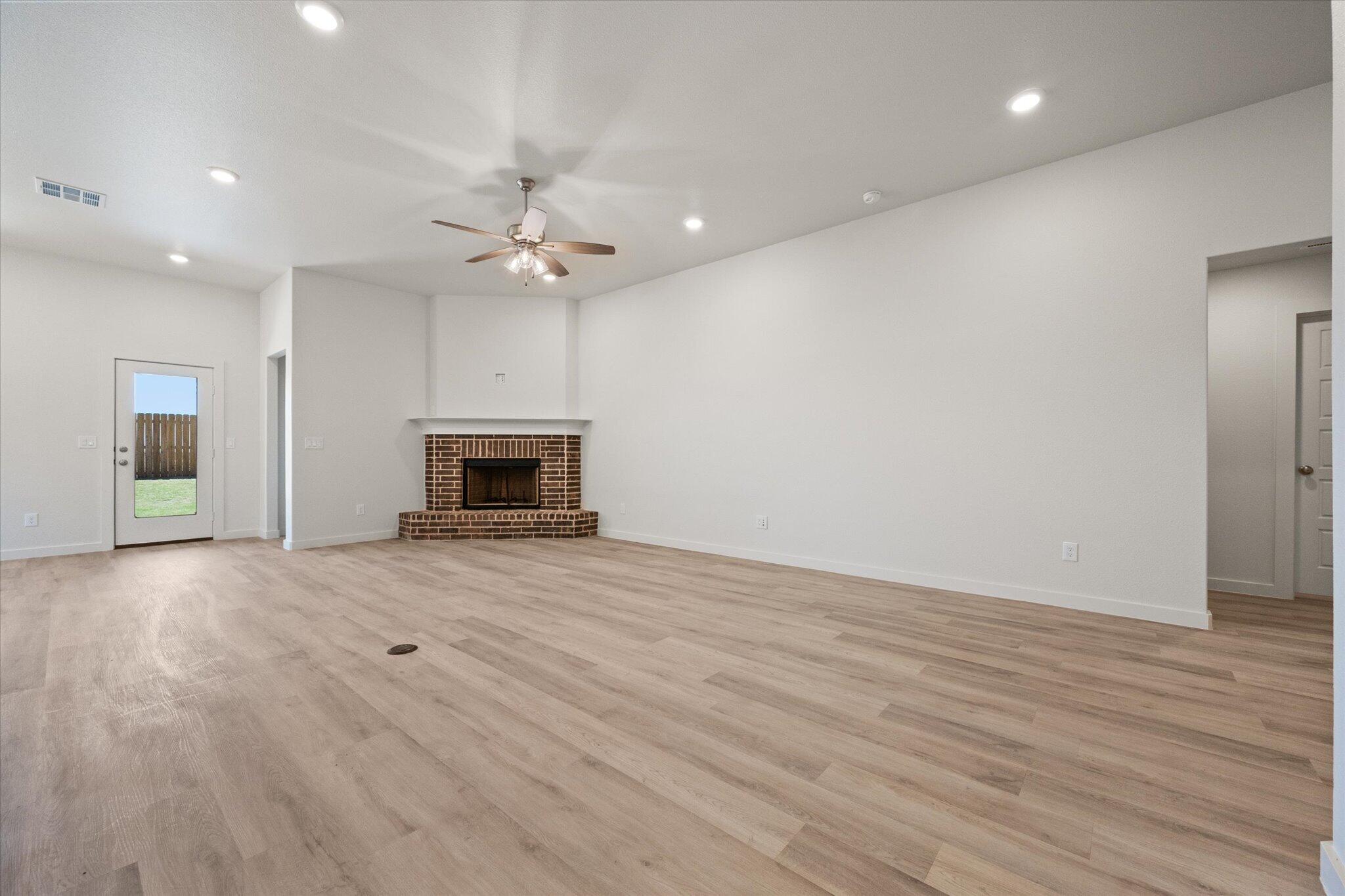 6105 121st Street Lubbock, TX 79424 - Photo 4 of 24 an empty room with fireplace cabinet and windows