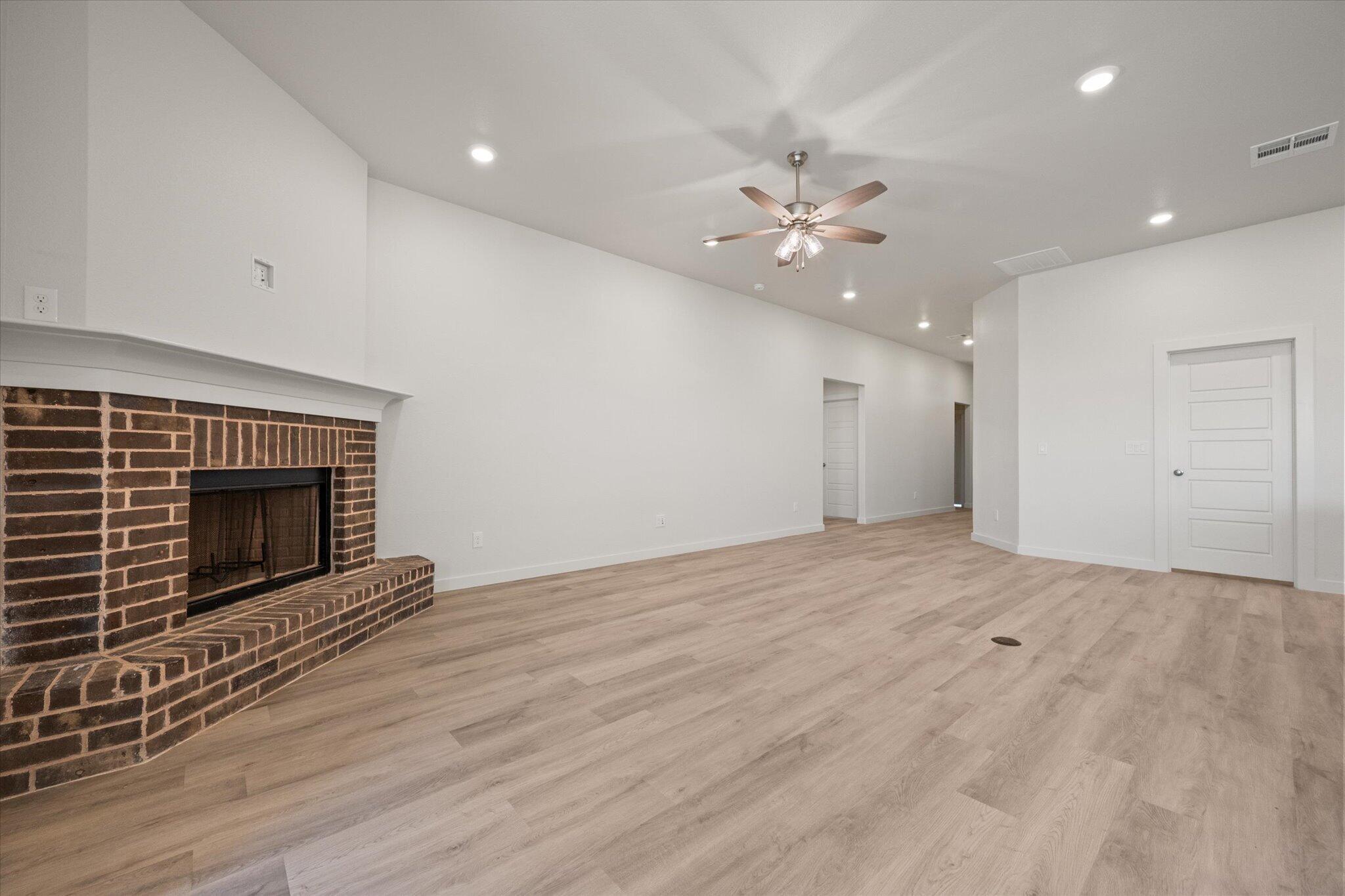 6105 121st Street Lubbock, TX 79424 - Photo 5 of 24 an empty room with fan and fireplace