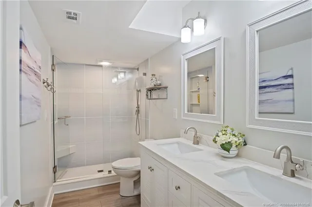 a bathroom with a sink a toilet and shower