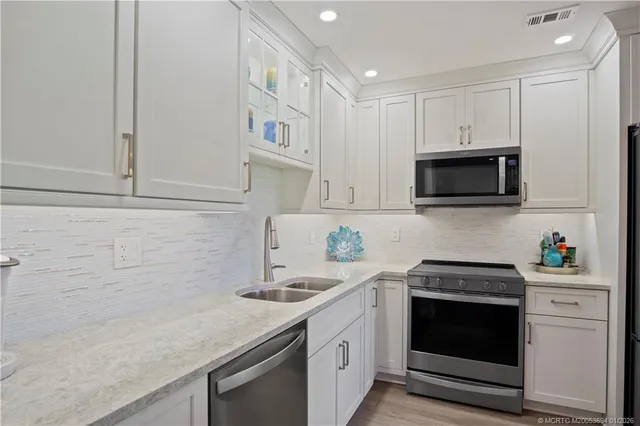 a kitchen with white cabinets and appliances