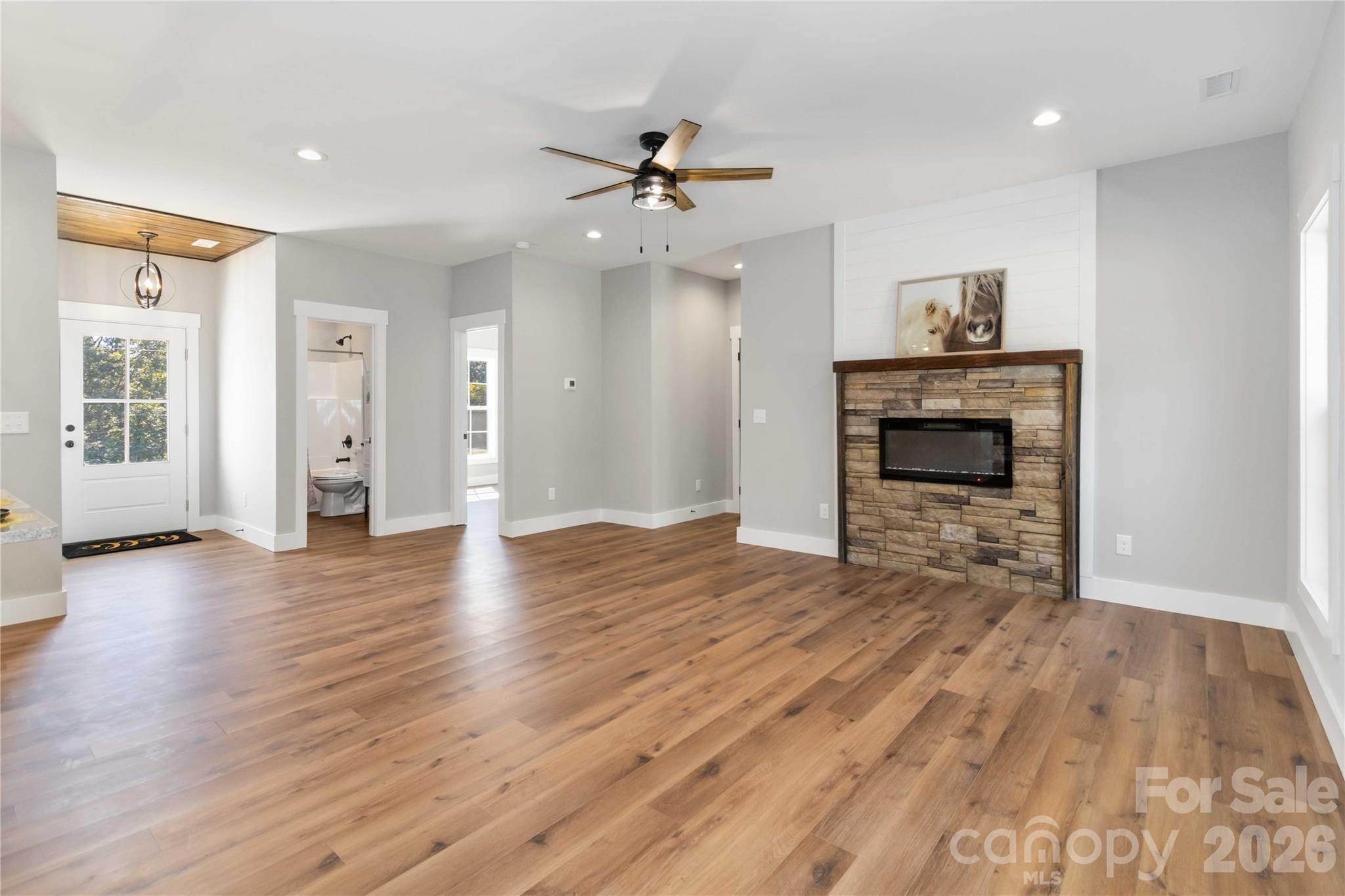 2605 Mt Prospect Road Chester, SC 29706 - Photo 5 of 35 an empty room with wooden floor fireplace and windows