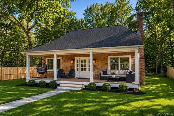 a porch with a table and chairs in front of house