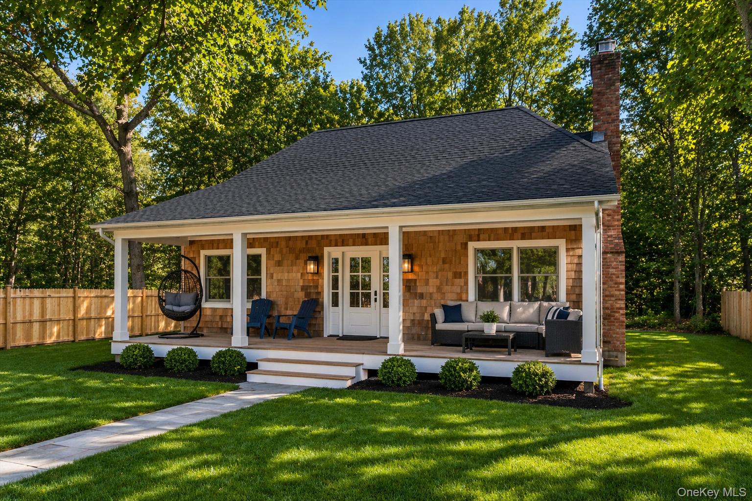 a porch with a table and chairs in front of house