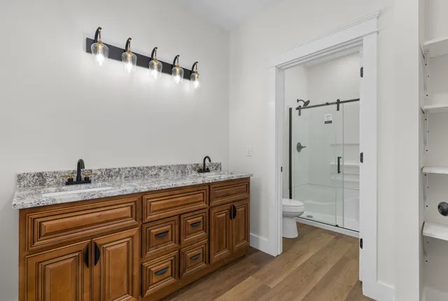 a bathroom with a granite countertop sink a toilet and a mirror