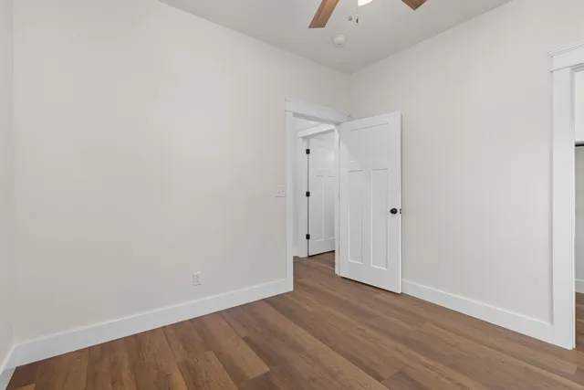 a view of an empty room with a chandelier fan