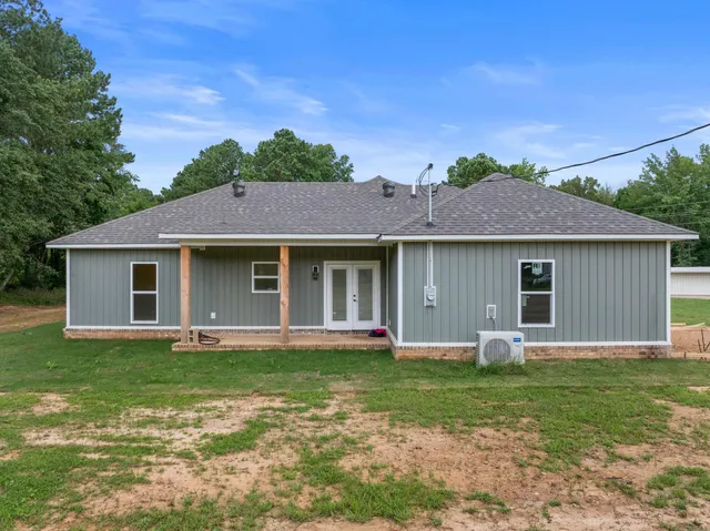 a front view of a house with a garden and yard