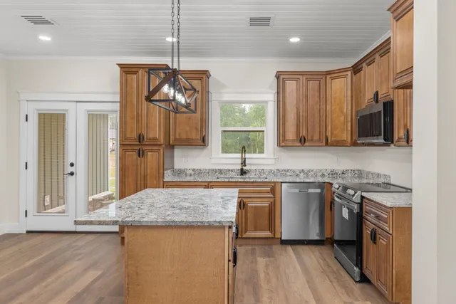 a kitchen with stainless steel appliances granite countertop a sink stove and refrigerator
