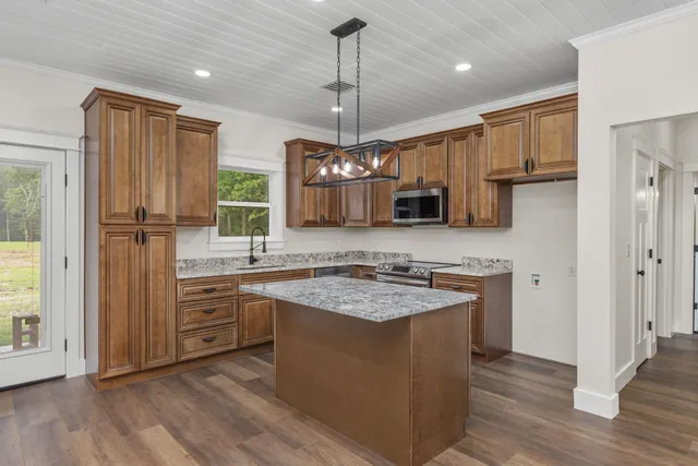 a kitchen with stainless steel appliances granite countertop a sink refrigerator and cabinets