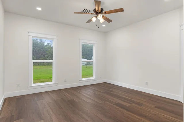 wooden floor in an empty room with a window