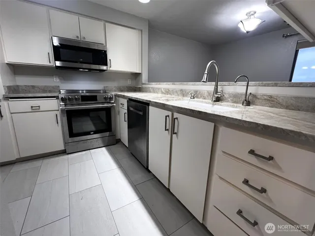a kitchen with stainless steel appliances granite countertop a sink and a stove