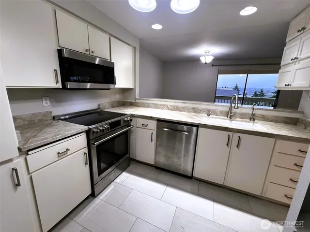 a kitchen with stainless steel appliances granite countertop a sink and a stove