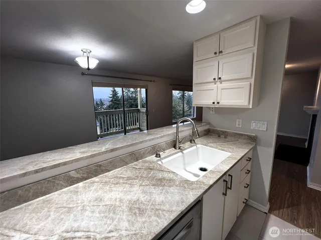 a bathroom with a granite countertop sink and a window