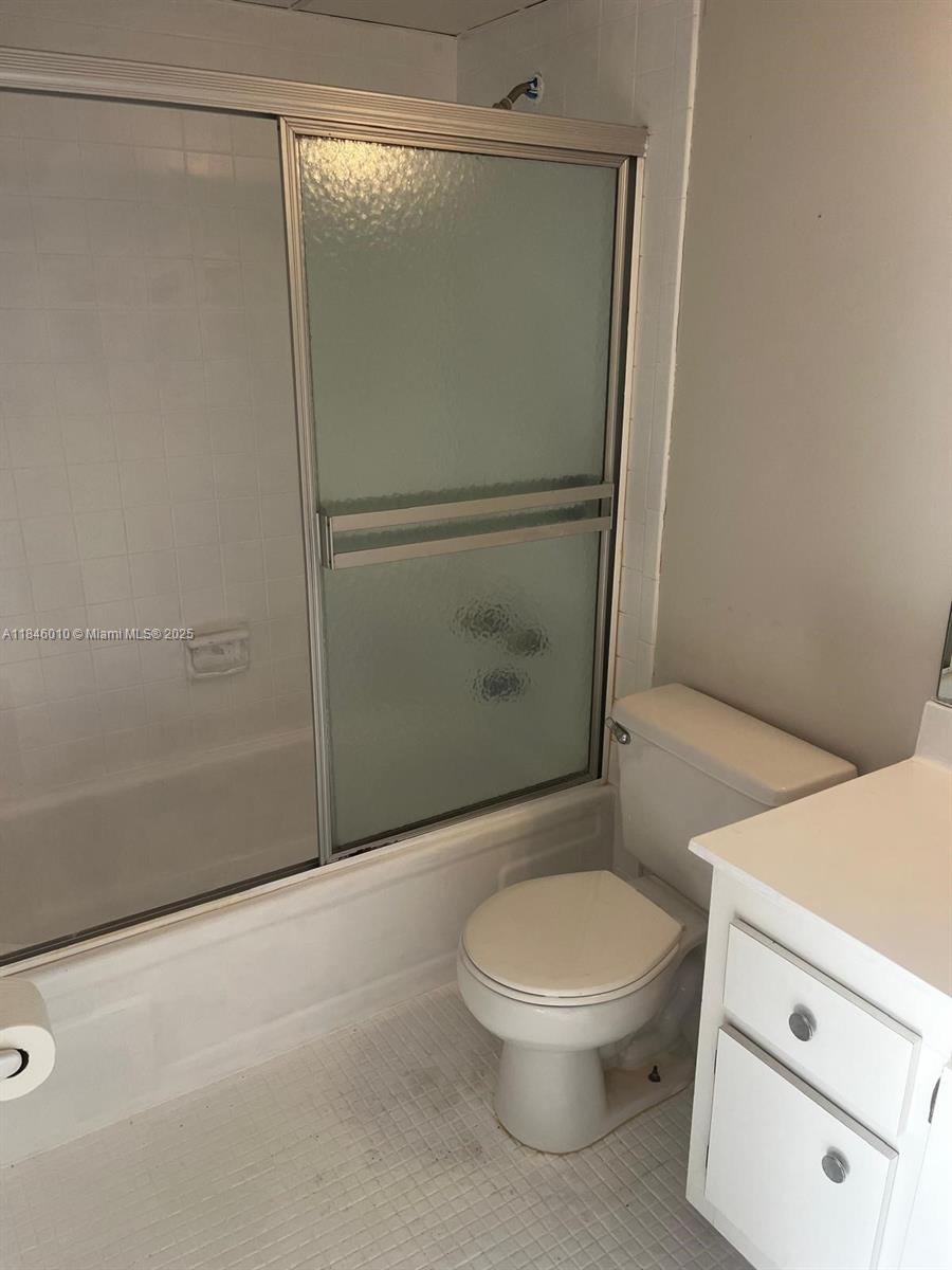 1015 Country Club Drive, Unit 302 Margate, FL 33063 - Photo 6 of 9 a white toilet sitting next to a bathroom sink