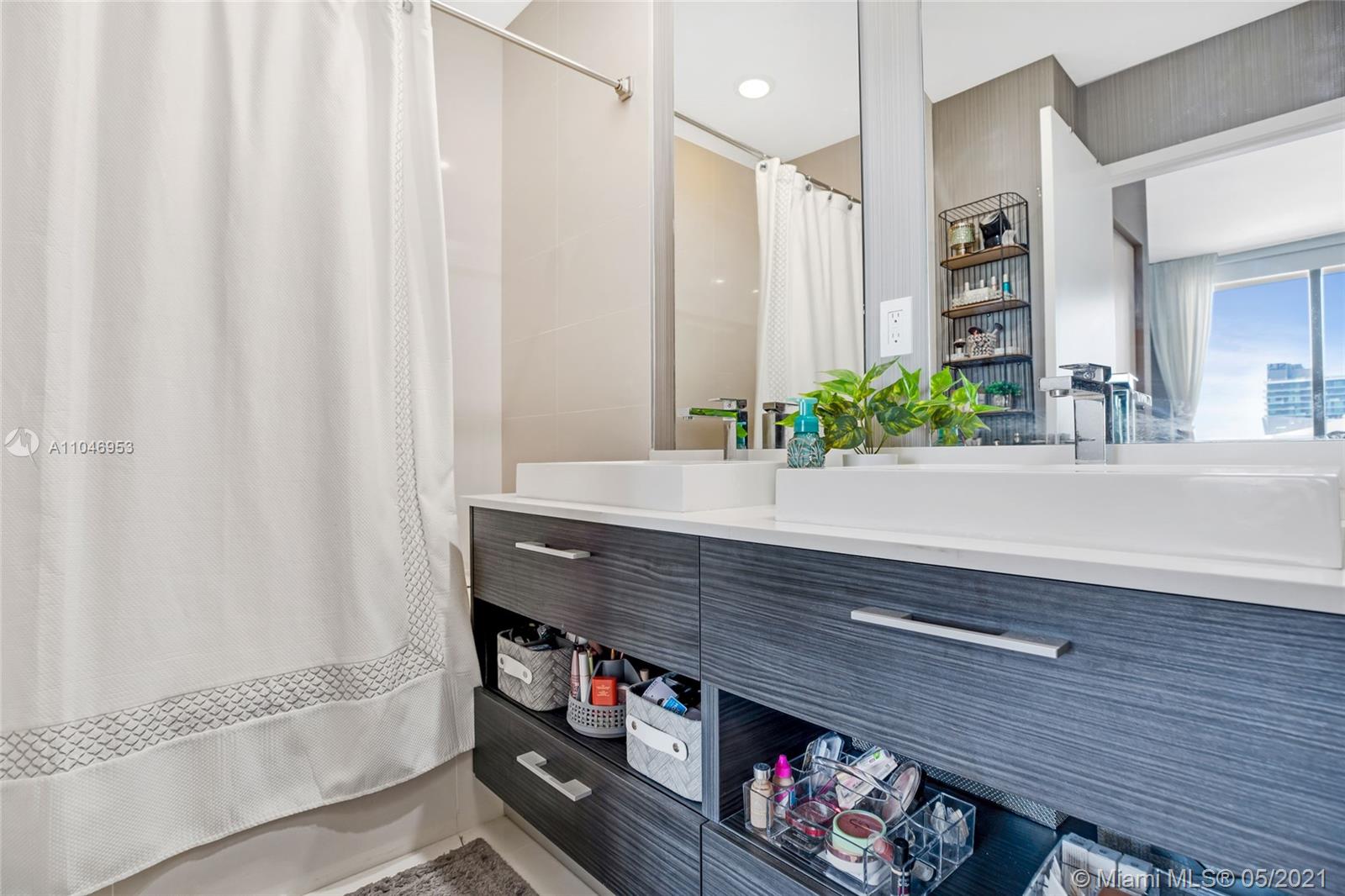 45 Southwest 9th Street, Unit 4204 Miami, FL 33130 - Photo 12 of 66 a bathroom with a sink and a mirror