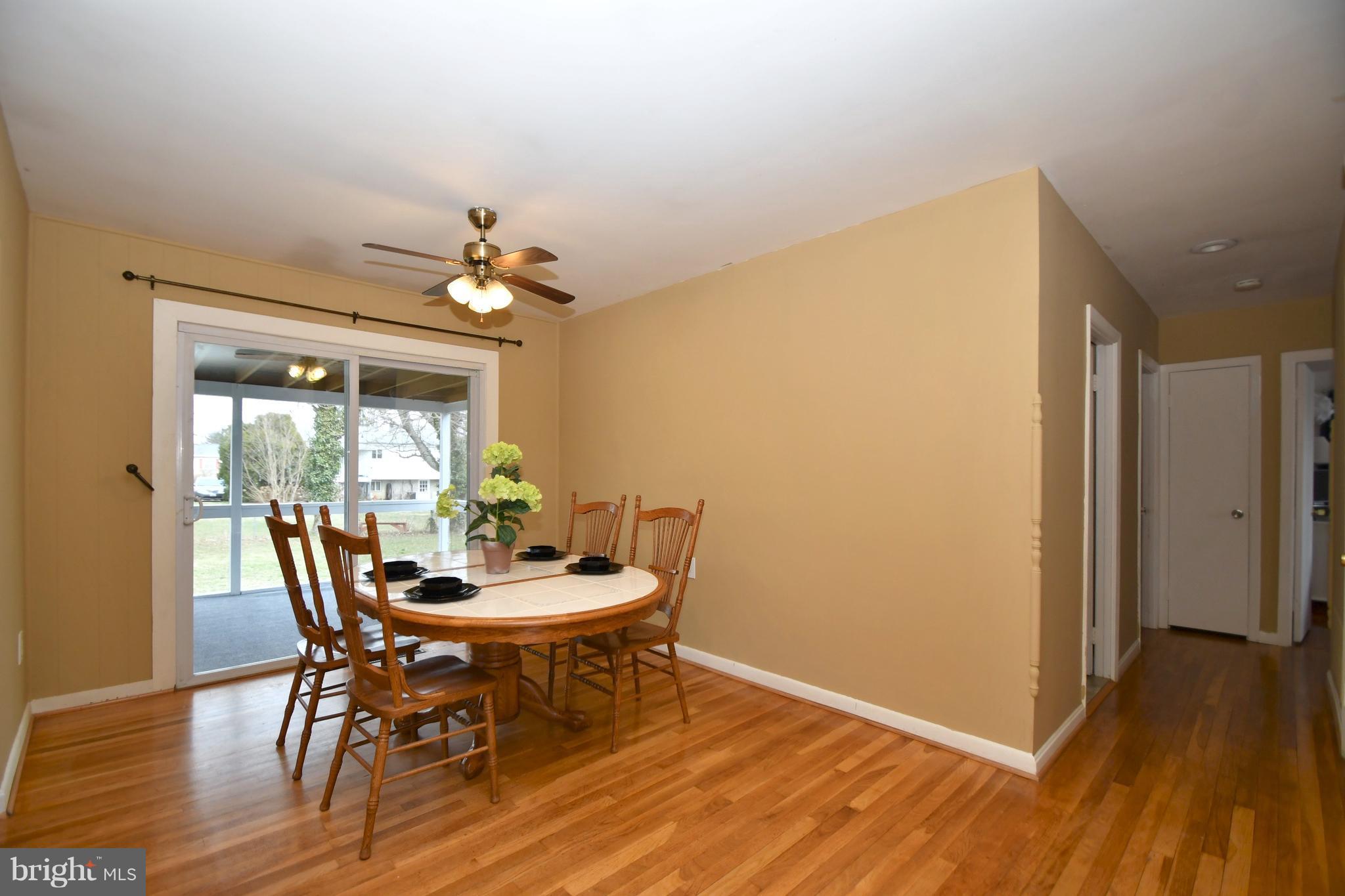 6102 Chanceford Road Baltimore, MD 21228 - Photo 7 of 30 a dining room with furniture wooden floor and a chandelier