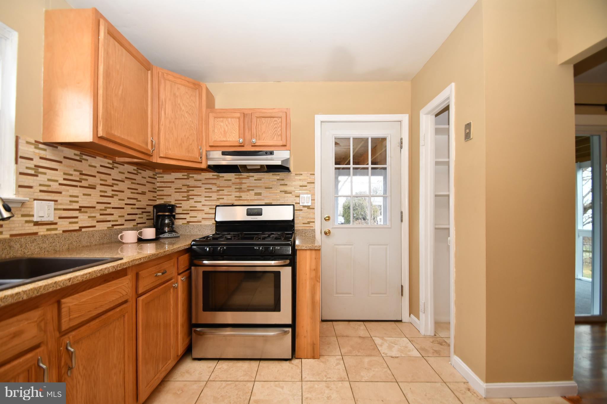 6102 Chanceford Road Baltimore, MD 21228 - Photo 9 of 30 a kitchen with a stove sink and cabinets