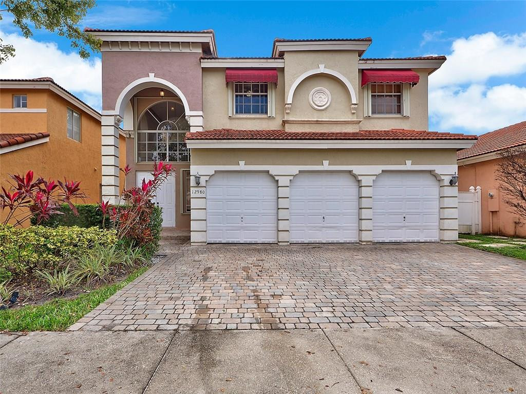 12980 Southwest 52nd Street Miramar, FL 33027 - Photo 16 of 17 a front view of a house with a garden